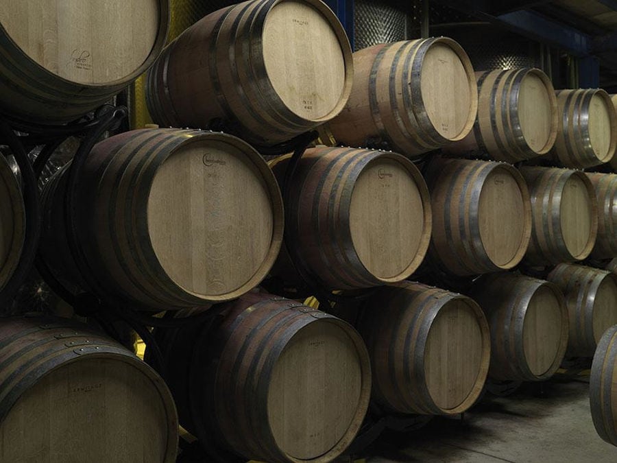 wine wood barrels on top of each other at Strofilia winery cellar